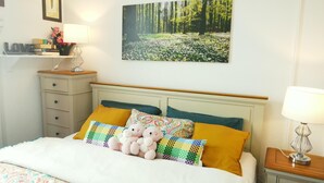 A bedroom with a bed, pillows, a nightstand, a lamp, a clock, and a framed picture on the wall. - Stylish 2 Bed Room Apartment 3 Sleep Free Wifi & p (Newport)