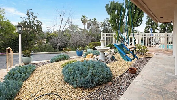 A garden with a fountain, a swing set, and various plants. - Designer Poolside La Mesa Retreat w/ BBQ & Yard (La Mesa)