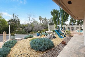 A garden with a fountain, a swing set, and various plants. - Designer Poolside La Mesa Retreat w/ BBQ & Yard (La Mesa)