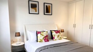 A hotel room with a bed, two nightstands, a round side table, and a wardrobe. - Superb 2 Beds Flat in The heart ofLondon! (London)