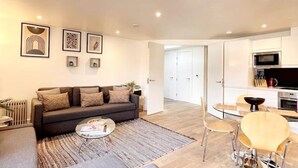 A modern living room with a sofa, coffee table, and artwork on the wall. - Superb 2 Beds Flat in The heart ofLondon! (London)