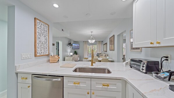 Enjoy cooking in this well-lit kitchen with a dishwasher and compact refrigerator.