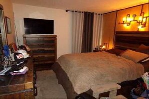 Relax in comfort with a large bed, dresser, and TV for a restful stay.