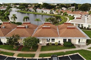 Houses line a tranquil street with a body of water in the background.