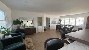 Ein geräumiger Wohnbereich mit Esstisch und Stühlen, einer Küchenzeile und einer Sitzecke mit Sofas.