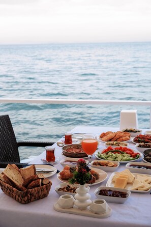 A table set with breakfast items and a view of the sea. - Black Lotus İzmir (Izmir)