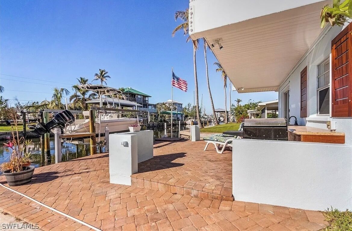 Eine Terrassenanlage mit Pool, Gartenmöbeln und Blick auf ein Gebäude mit einer amerikanischen Flagge.