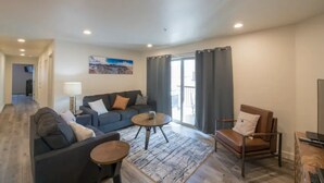 A modern living room with a sofa, armchair, coffee table, and a view of the outdoors. - 4-E The Hidden Valley Condo (Second Floor/Parking Lot Side) (Moab)