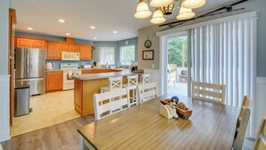 Een moderne keuken met houten kastjes, roestvrijstalen apparatuur en een centraal kookeiland met zitplaatsen.