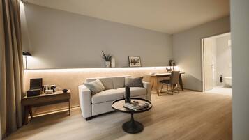 Una sala moderna con un sofá, una mesa de centro y una zona de escritorio.