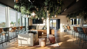 Un área de descanso moderna con asientos, bar y ventanas amplias que ofrecen vistas.