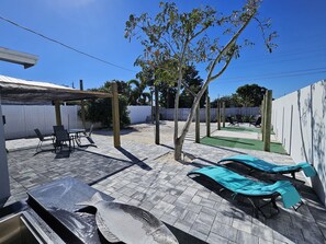 A patio area with a covered seating area, a pool, and lounge chairs. - Minutes from the downtown life of Delray Beach and a mile away from the beach! (Delray Beach)