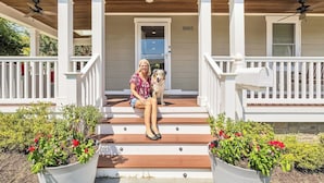 A porch with a person and a dog, a mailbox, and a door with the number 5005. - Pet-friendly, large yard, flexible extensions (Arlington)