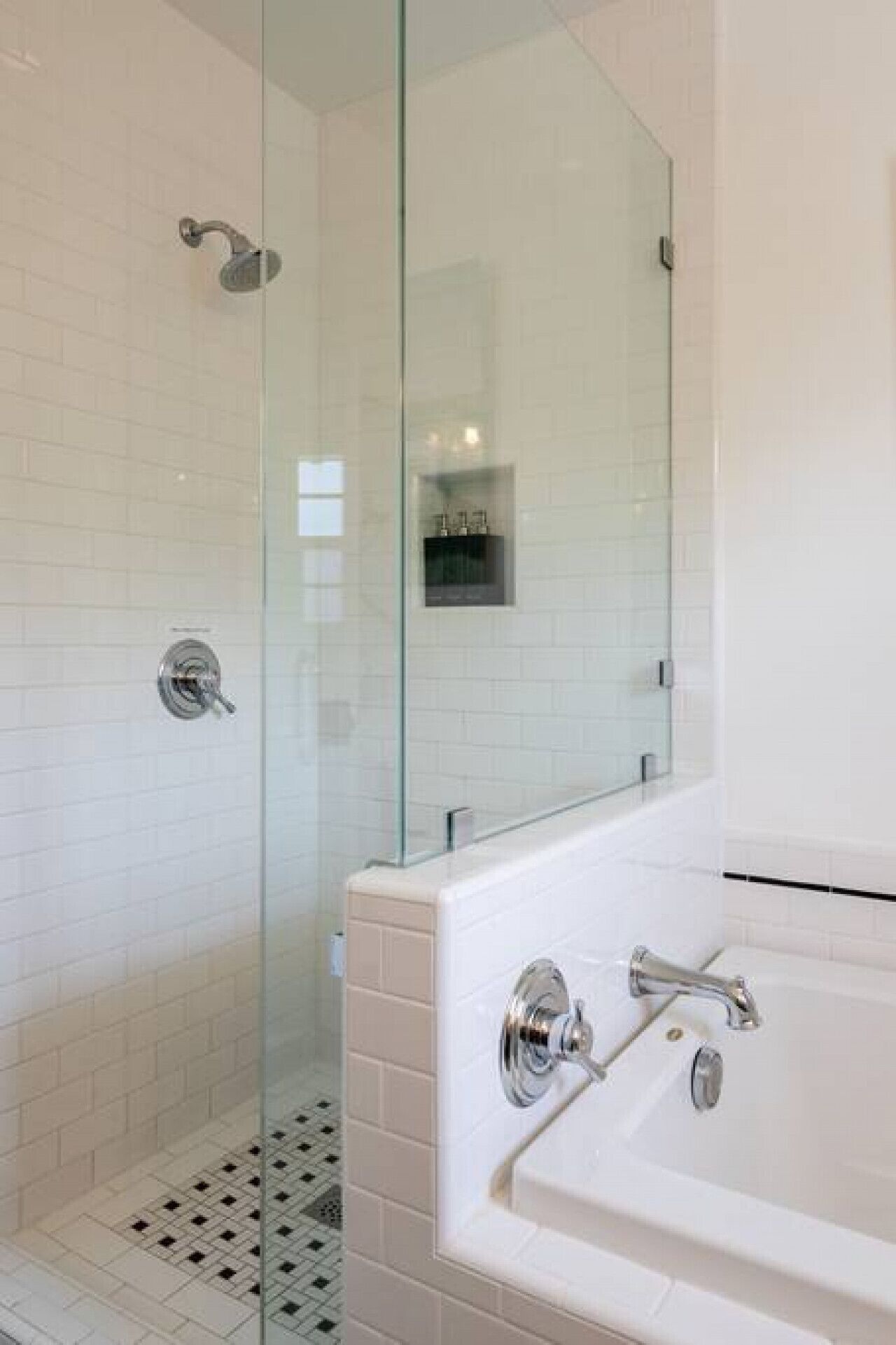 Une salle de bain moderne avec une douche à l’italienne, une baignoire blanche et un sol carrelé.