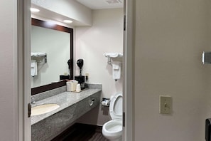 A bathroom with a sink, mirror, toilet, and towel rack.