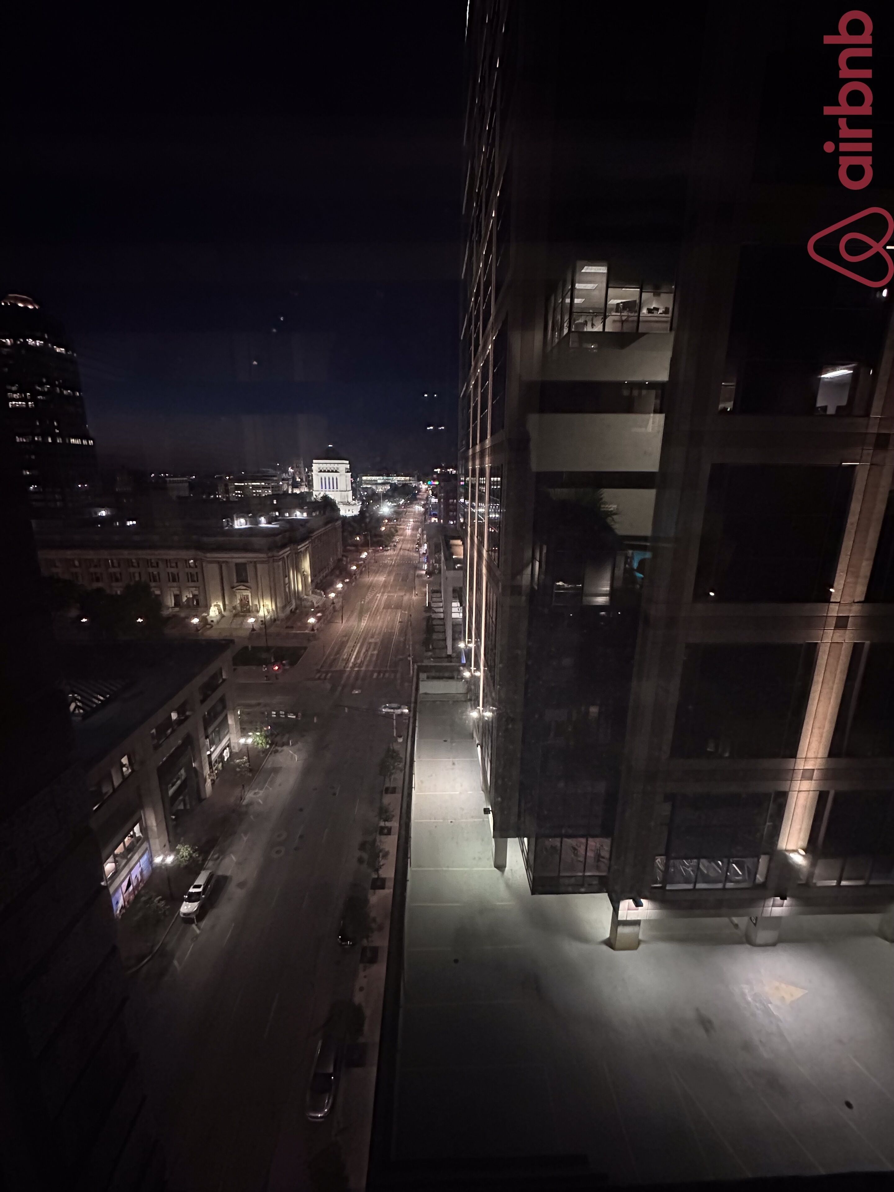 Un paisaje urbano nocturno con un edificio de varios pisos y balcones.