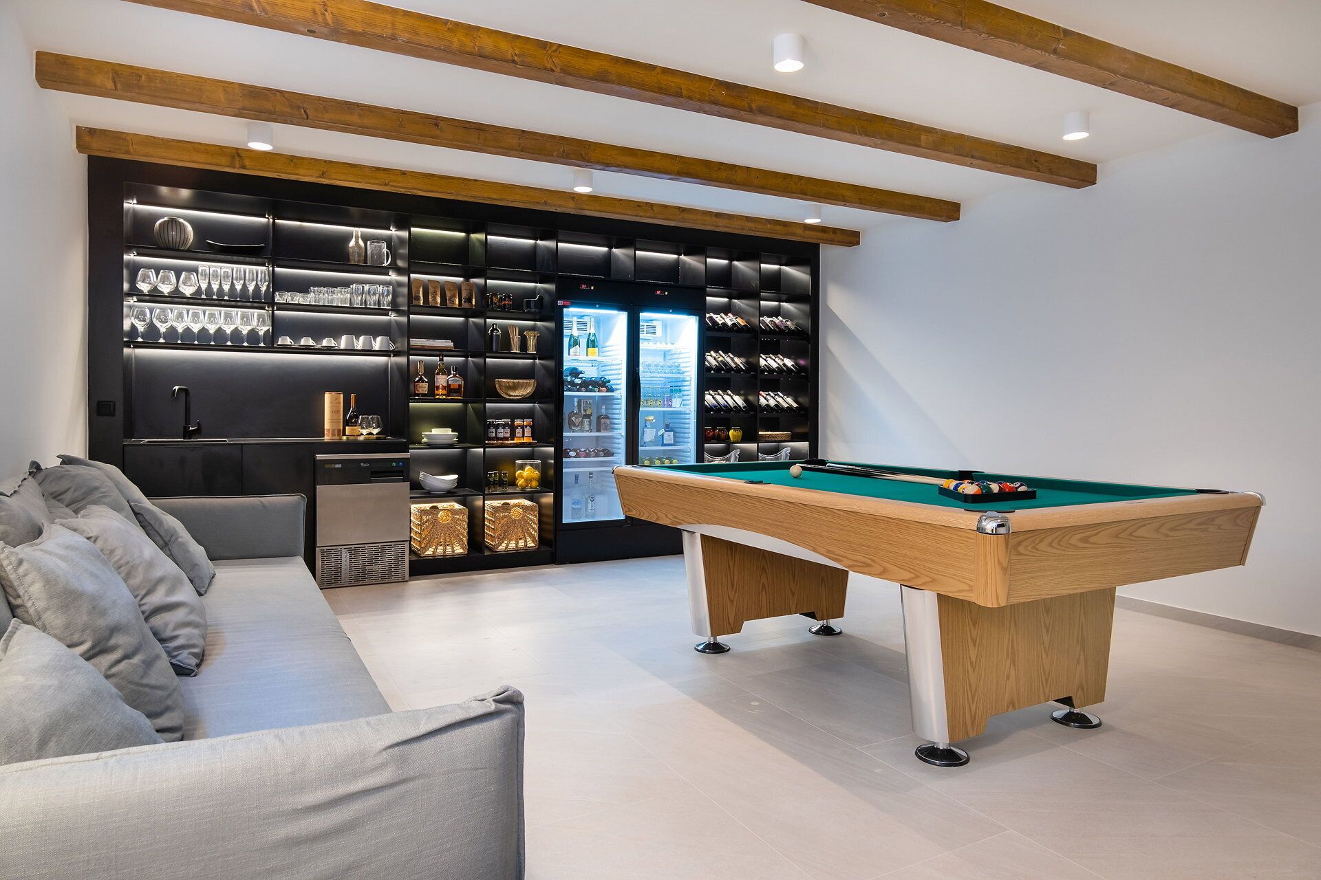 Un salon moderne avec une table de billard, un canapé et un meuble-bar.