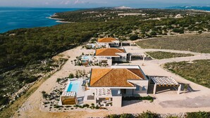 Una proprietà costiera con diverse ville, una piscina e vista sul mare.