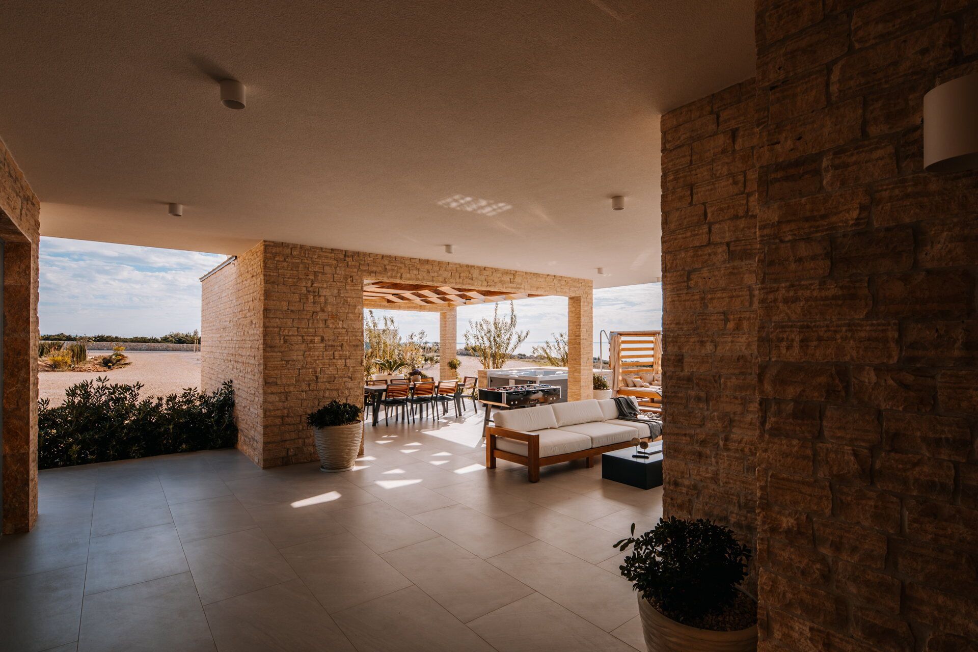 A spacious patio with a dining area, outdoor seating, and a sofa.