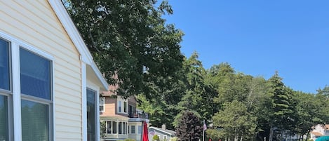 Ein Steg mit einem Boot, eine Holzpier und ein Haus mit weißer Fassade.