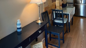 A dining area with a wooden table and chairs, a lamp, and a wall decorated with wooden boxes. - 2 Bed/1 Bath Saunders Bay Gilford with boat slip. Walk to Meadowbrook for a show (Gilford)