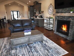 Cozy living room with a fireplace, leather sofa, and wooden coffee table.