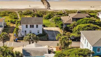 A coastal residential area with houses, a beach, and a clear sky.