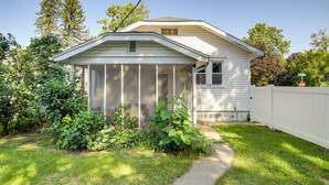 A single-story house with a covered porch, surrounded by a white fence and lush greenery. - Notre Dame Weekends, Roughly 1-Mi Walk to Stadium (South Bend)