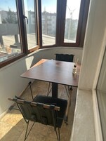 Habitación de esquina con una mesa de madera y dos sillas negras.