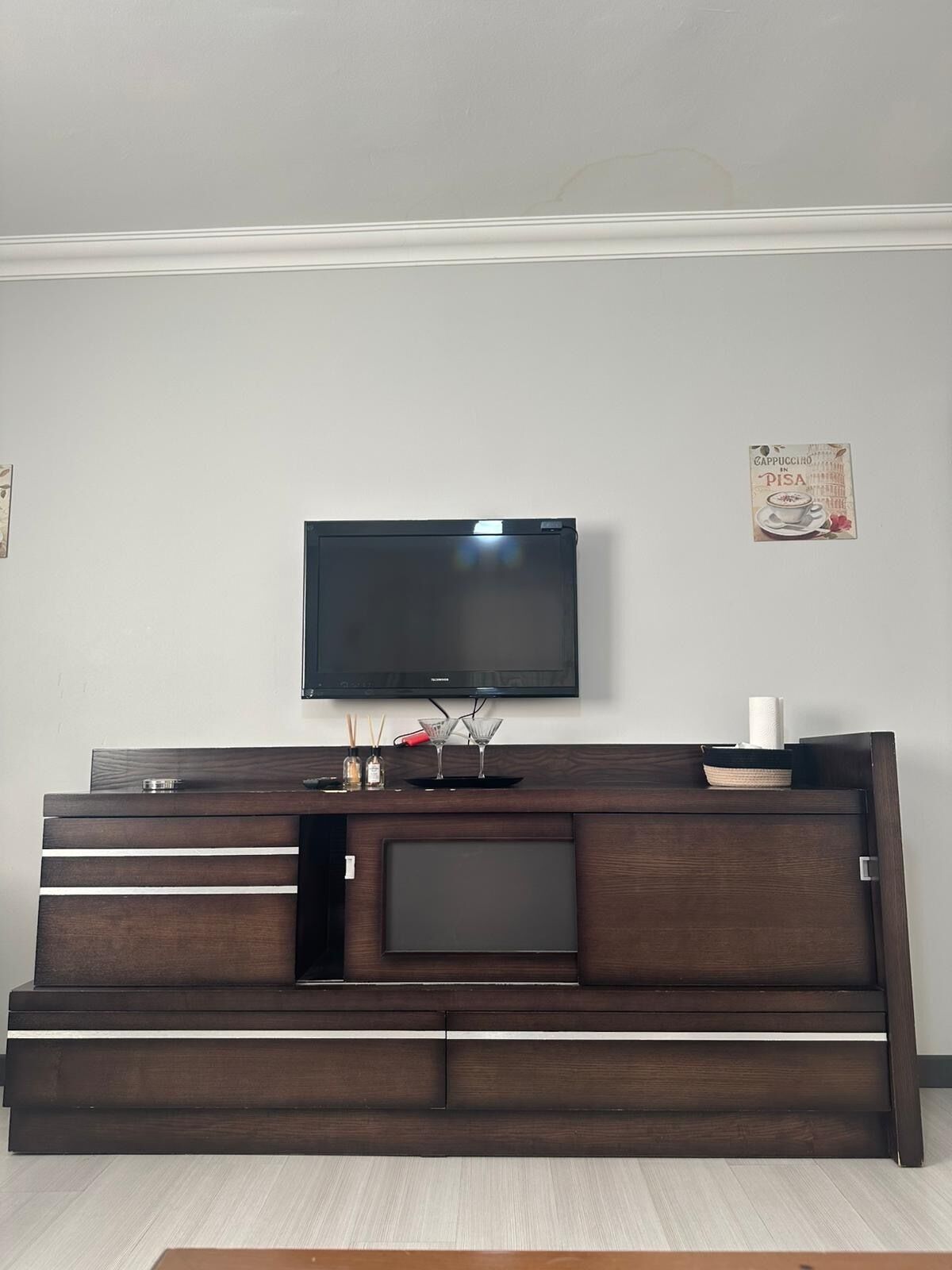 Un mueble multimedia de madera oscura con un televisor de pantalla plana montado encima.