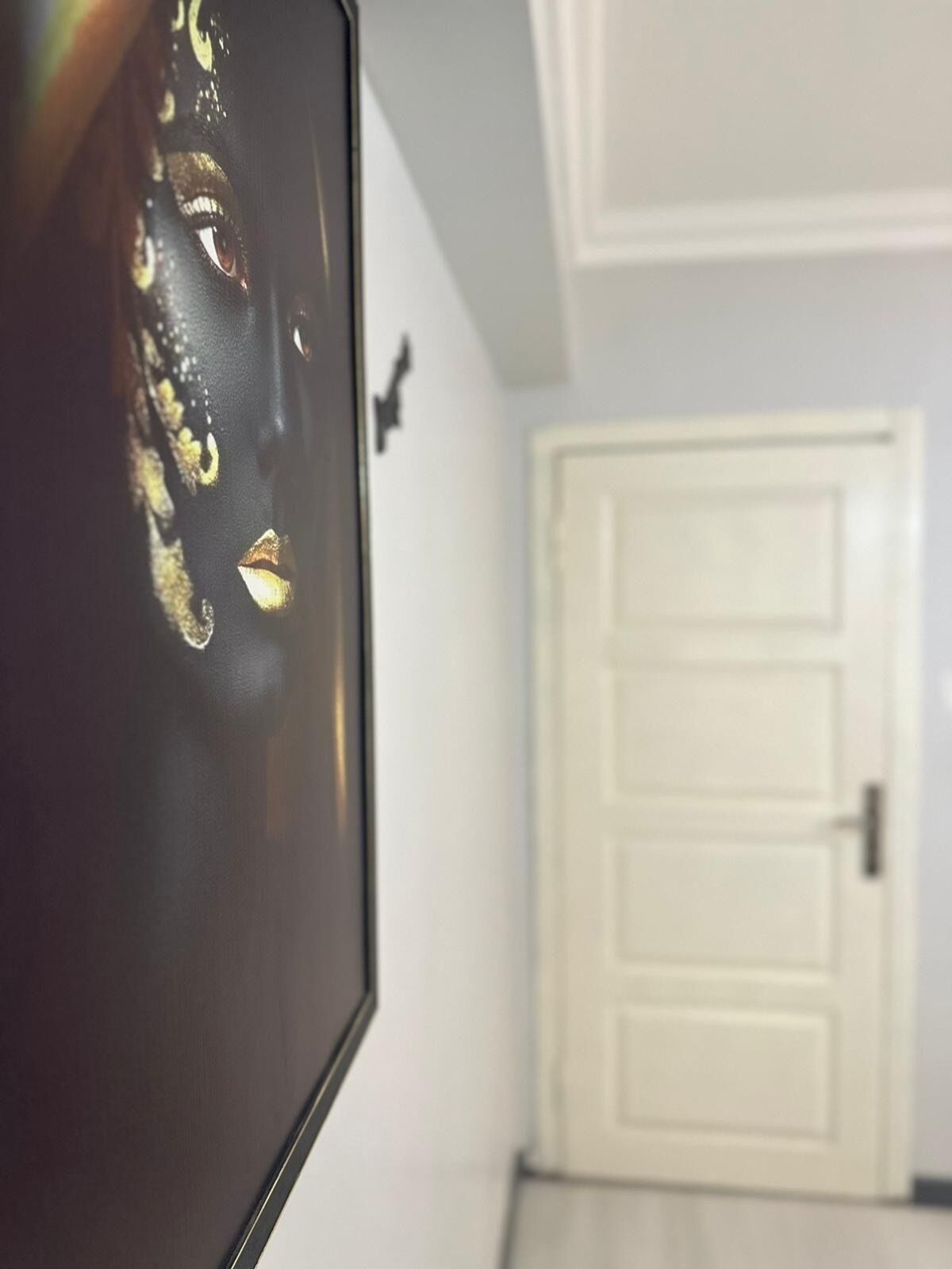 Una habitación con una puerta blanca y un objeto negro con detalles dorados.