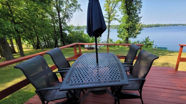 Eine Terrasse mit Tisch und Stühlen mit Blick auf einen See.