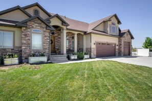 A two-story house with a stone facade, a front porch, and a garage.