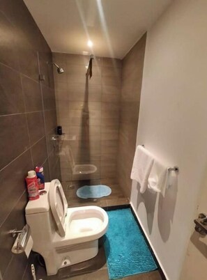 Une petite salle de bain moderne équipée de toilettes, d’un bidet et d’une douche.