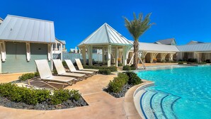 A pool area with lounge chairs, a gazebo, and a clear blue sky. - Luxe Palmilla Beach home with Gulf view, guest suite, pool access, walk to beach (Port Aransas)
