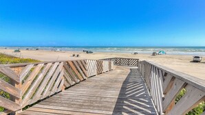 A wooden boardwalk leading to a beach with clear skies. - Luxe Palmilla Beach home with Gulf view, guest suite, pool access, walk to beach (Port Aransas)
