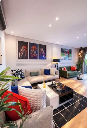 A modern living room with a sofa, coffee table, and artwork on the wall.