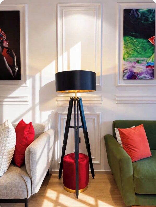 A modern living room with a floor lamp, two sofas, and artwork on the walls.