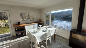 Una cucina moderna con zona pranzo, ampie finestre e un camino a legna.