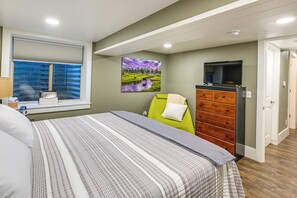 A bedroom with a bed, a dresser, a television, and a window with blinds. - Laramie Gem < 1/2 Mi to University of Wyoming! (Laramie)