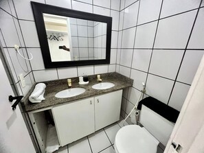 Chuveiro, secador de cabelo, toalhas de banho, papel higiênico