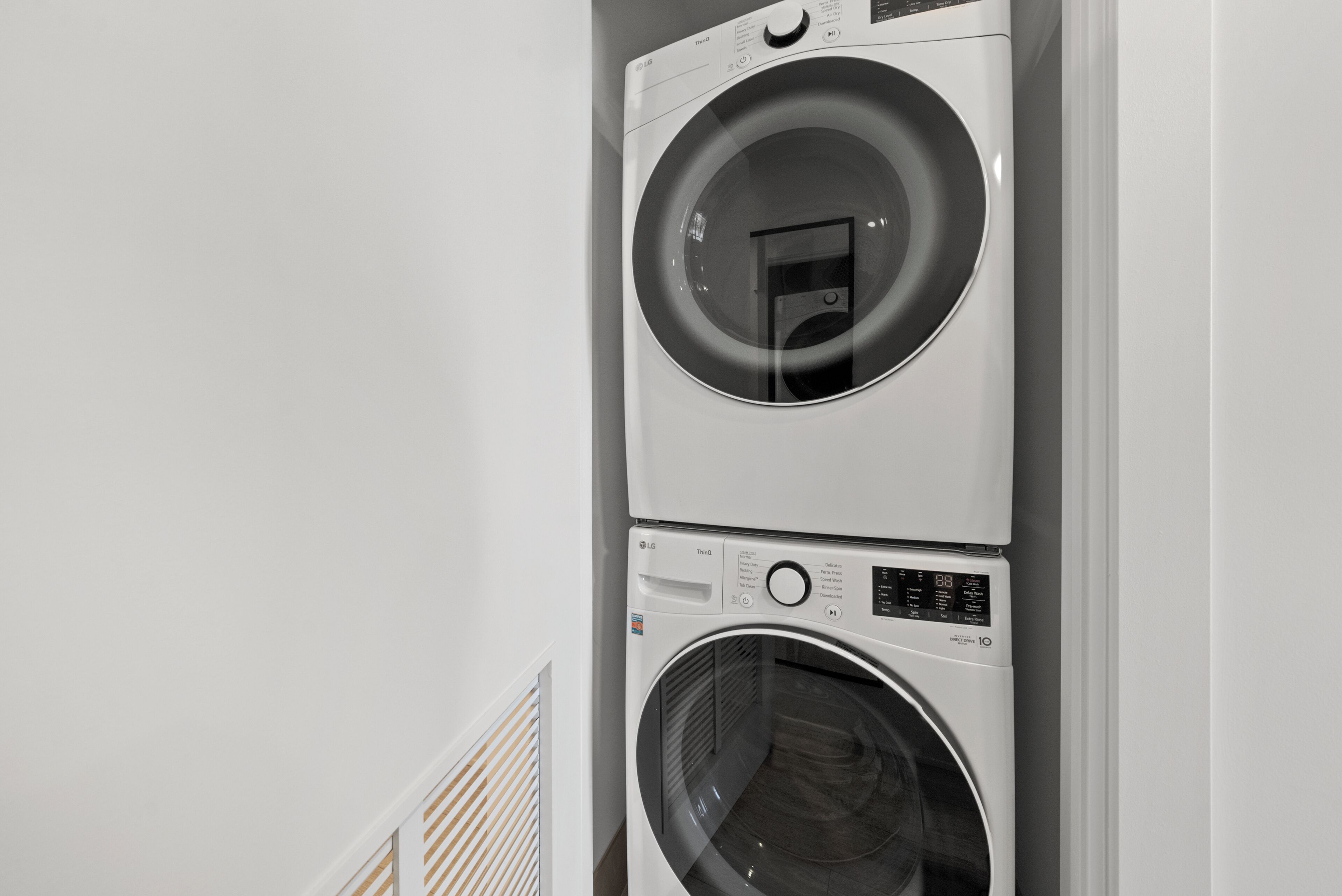 A stacked washer and dryer unit in a laundry room.