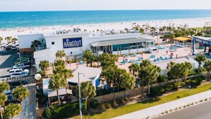 A hotel named 'The Hangout' with a beach view, outdoor seating area, and palm trees. - Close to Everything in Gulf Shores! 5 BR house w/Private Pool (Gulf Shores)
