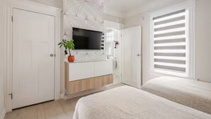 A modern bedroom with a bed, a TV, a plant, and a window with blinds. - CentralDowntownSanJose-Stunning, fireplace Modern Craftsman house/SAP, Airport (San Jose)