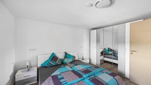 A modern bedroom with a bed, bedside table, and a wardrobe. - 1 bedroom cozy apartment in Seewald (Seewald)
