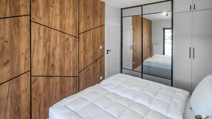 Une chambre à coucher avec un lit, une armoire en bois et une armoire avec des portes miroir.