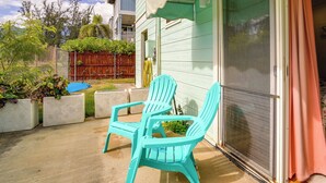 A patio with two turquoise chairs and a concrete floor. - Surfer's Paradise: Waialua Condo Steps to Beach! (Waialua)
