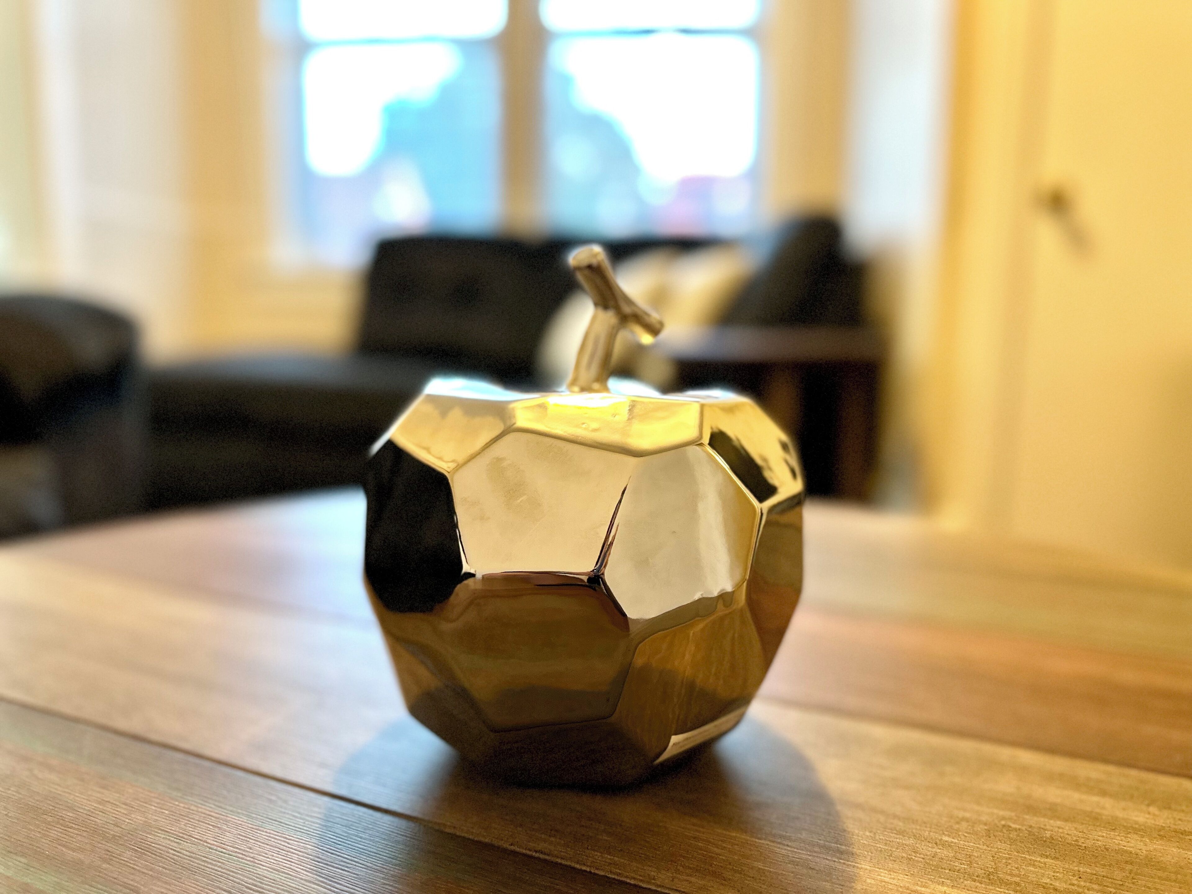 Een metalen object in geometrische vorm op een houten ondergrond.