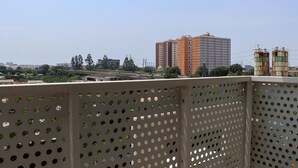 A high-rise building with multiple floors, surrounded by greenery and other buildings. - Good Deal and Comfy Studio West Vista Apartment (Jakarta)