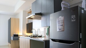 A modern kitchen with a stainless steel refrigerator, a microwave, and a gas stove. - Good Deal and Comfy Studio West Vista Apartment (Jakarta)
